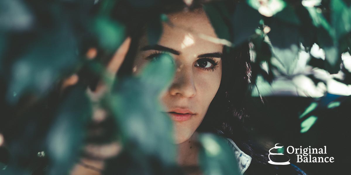 Original-Balance-Fear-Eradication-Mastery-photo-of-a-woman-hiding-behind-the-leaves